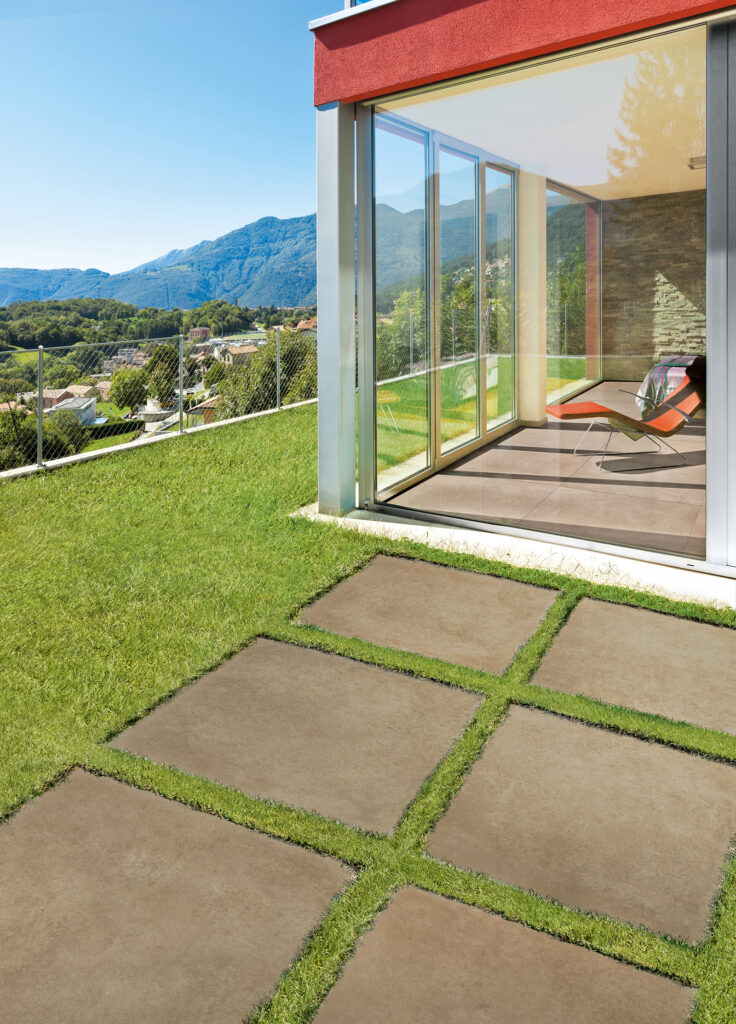 jardin privé avec pose de carreaux en grès effet beton sur gazon
