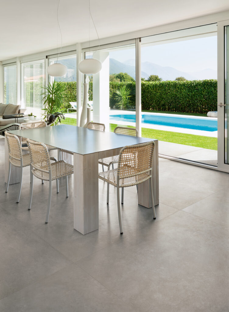 Detail eines offenen In&Out-Raums mit Küchentisch und Feinsteinzeugboden