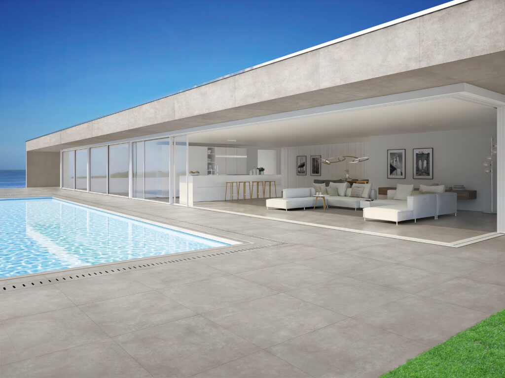 open space in&out con pavimento in gres effetto cemento e piscina