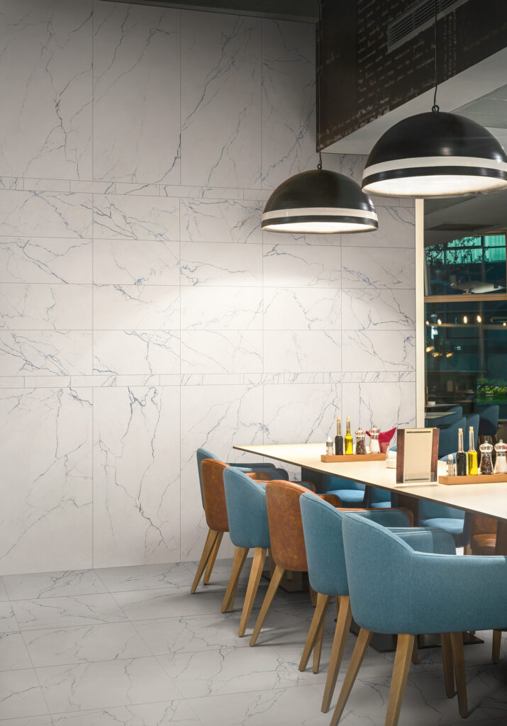 Restaurant mit einer Wand aus Feinsteinzeug in weißer Marmoroptik mit blauen Äderungen