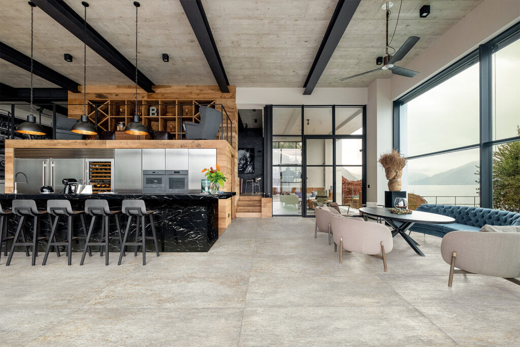 Küche mit Kochinsel und Essbereich, mit Feinsteinzeugboden in Metalloptik.