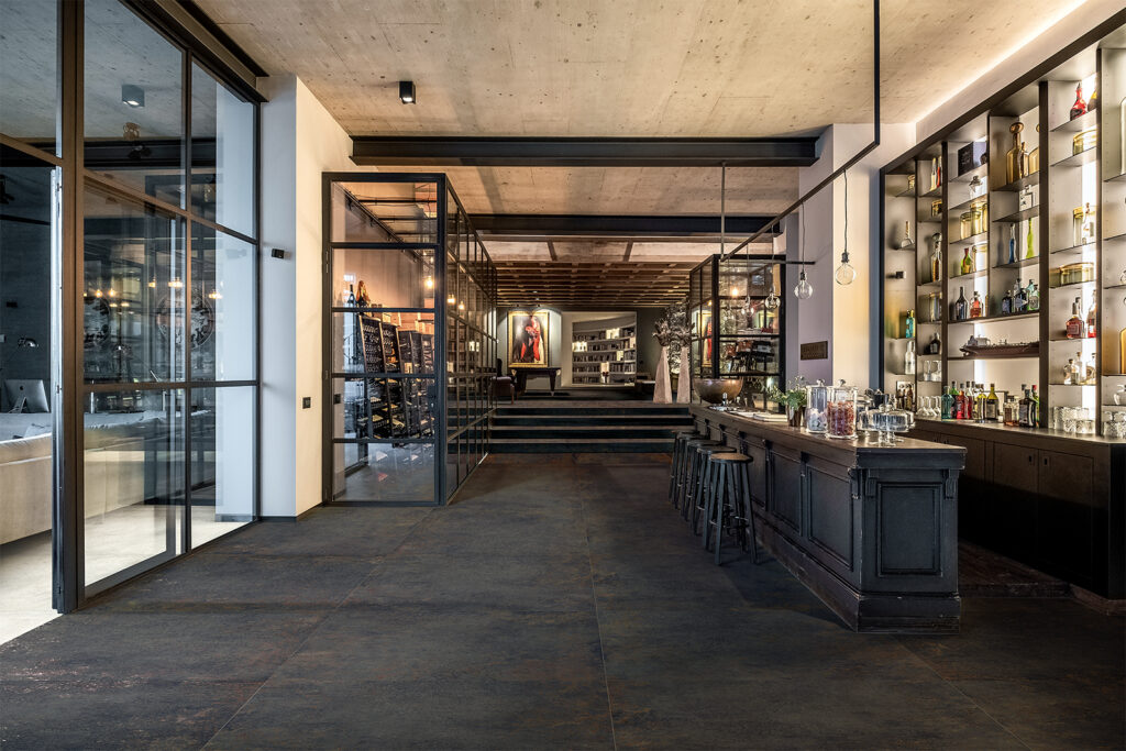 Privater Barbereich mit Weinkeller, ausgestattet mit Feinsteinzeugboden in Metalloptik.