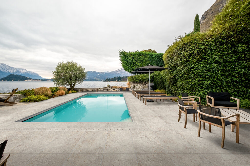 Outdoor-Poolboden aus Feinsteinzeug in Grau-Rost-Metalloptik.