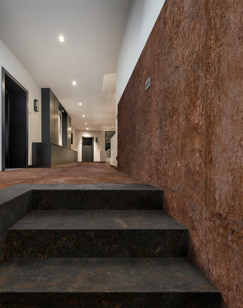 Escaliers intérieurs recouverts de grès cérame effet métal foncé.