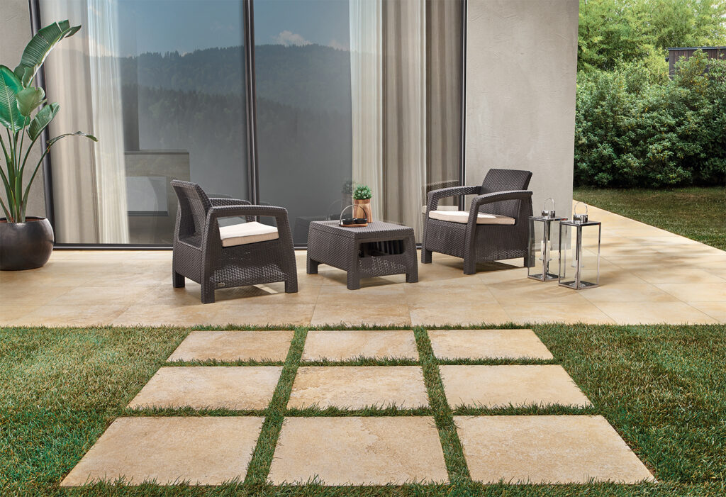 Espace de vie extérieur dans jardin privé avec carrelage en grès cérame effet pierre.