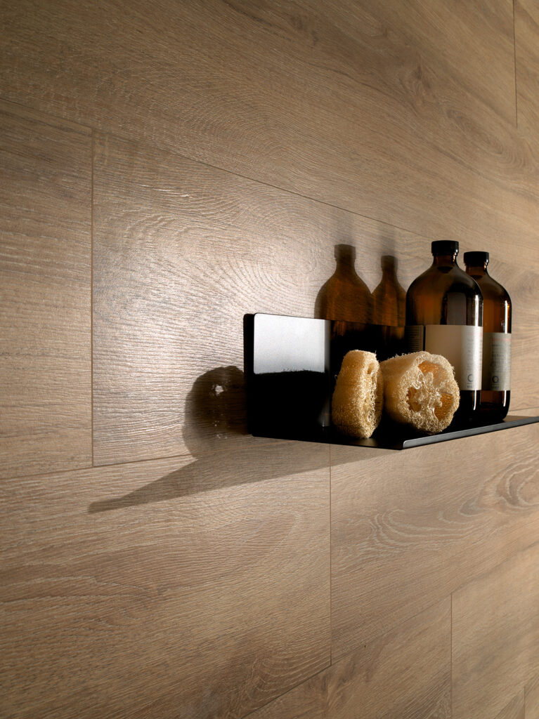 Détail de salle de bain avec revêtement en grès cérame effet bois marron et savons