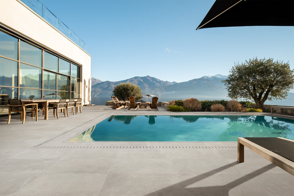 terrazza con rivestimento esterno piscina in gres effetto pietra grigio