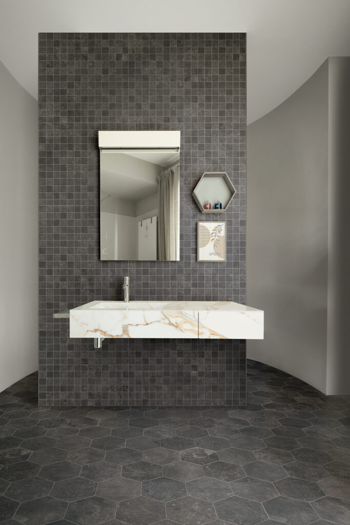 Salle de bains avec lavabo en grès cérame effet marbre, sol et mur en grès cérame effet pierre