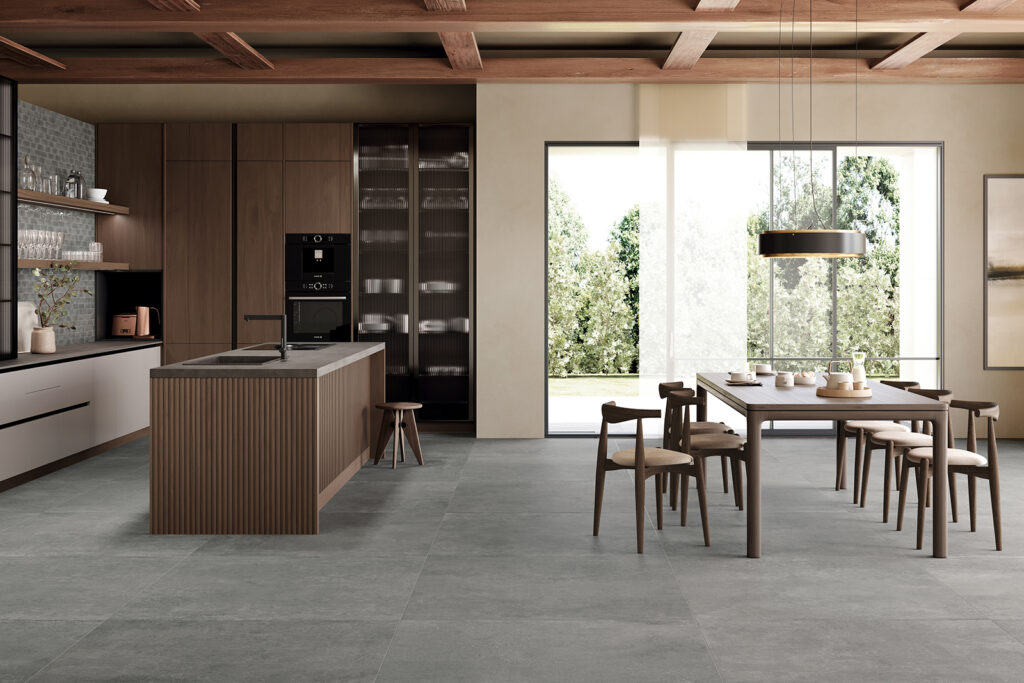 cucina con arredi e dettagli color legno, grande finestra e pavimento in gres