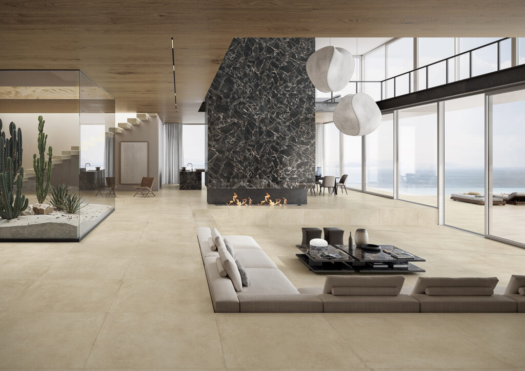 grande living con arredo di design, finiture in gres effetto cemento e marmo