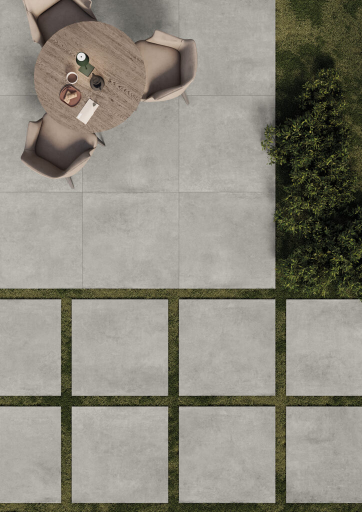 giardino di un bar con tavolino su base in gres effetto cemento grigio chiaro