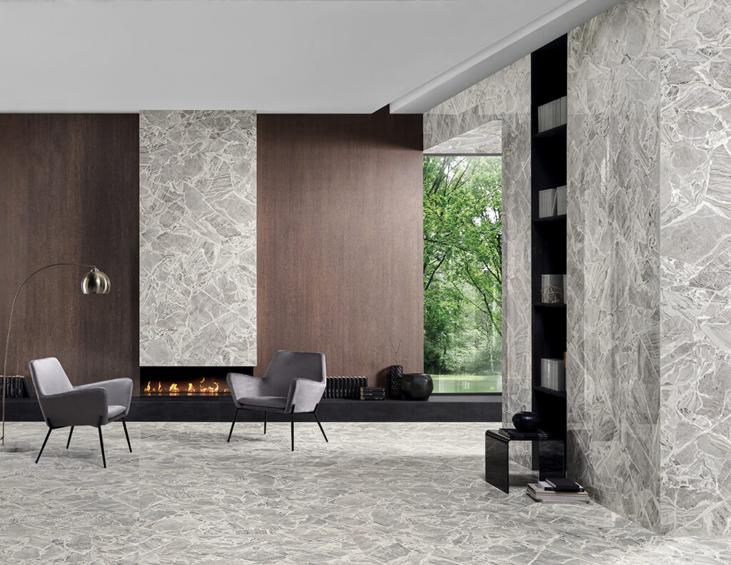 Living con mobile a terra e libreria, pavimento e rivestimento effetto marmo cenere con cristalli