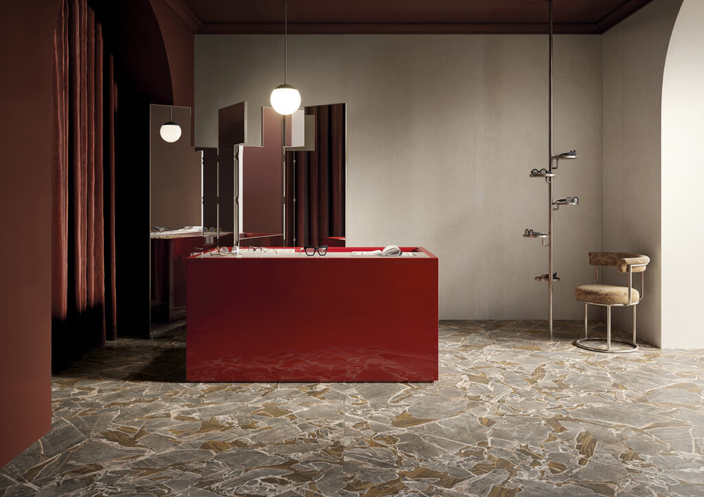 Negozio di occhiali con bancone rosso, pavimento effetto marmo dorato con cristalli