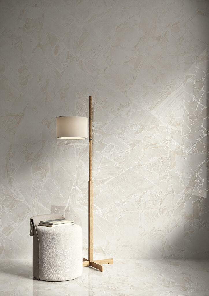 Living con puff e lampada, con dettaglio su rivestimento effetto marmo chiaro con cristalli